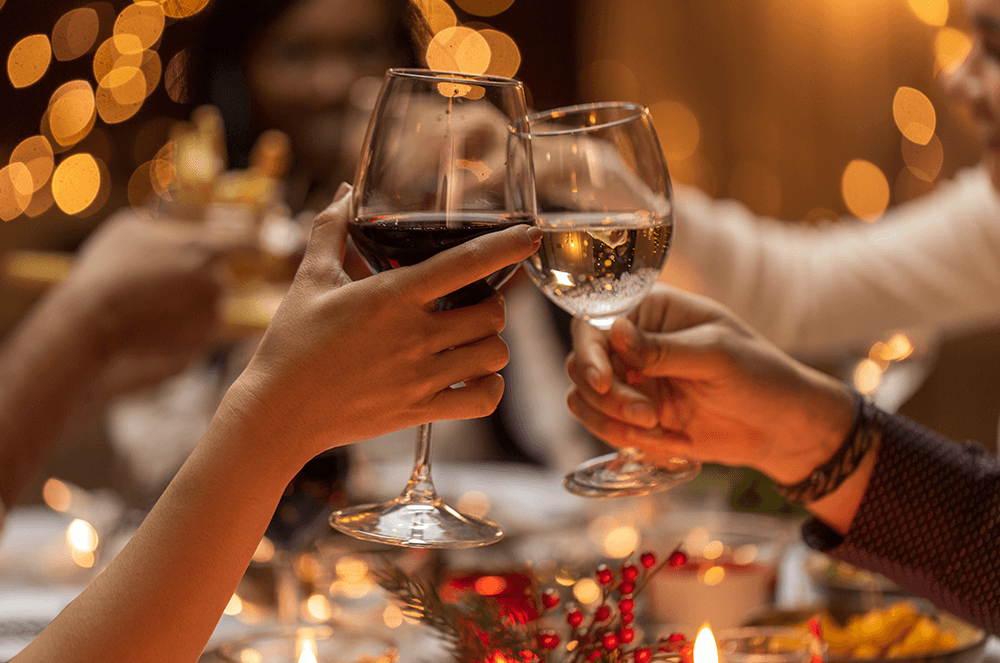 Two hands holding wine glasses and clinking