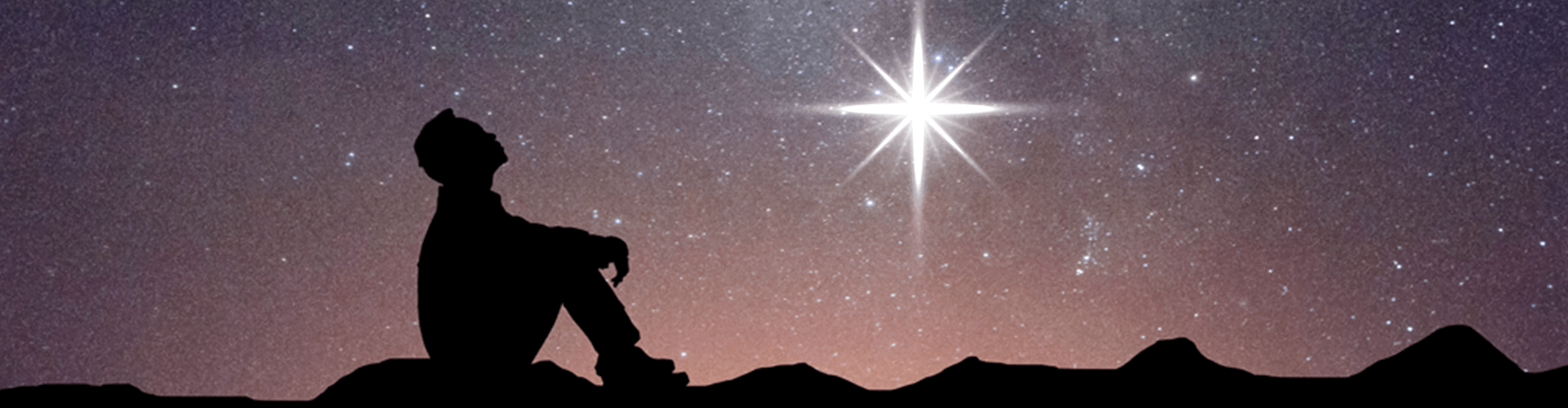 Silhouette of man gazing up at starry sky