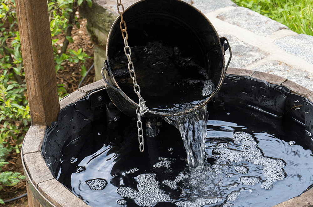 Well with bucket of water pouring into it