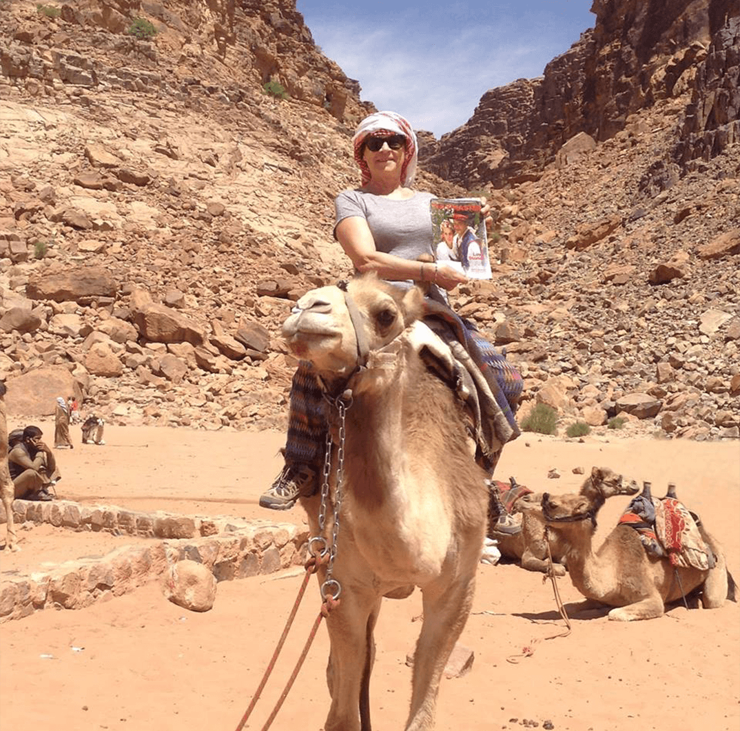 Martine Gouardo Marsat of Brussels, Belgium, enjoys a camel ride in the Wadi Rum desert, Jordan.