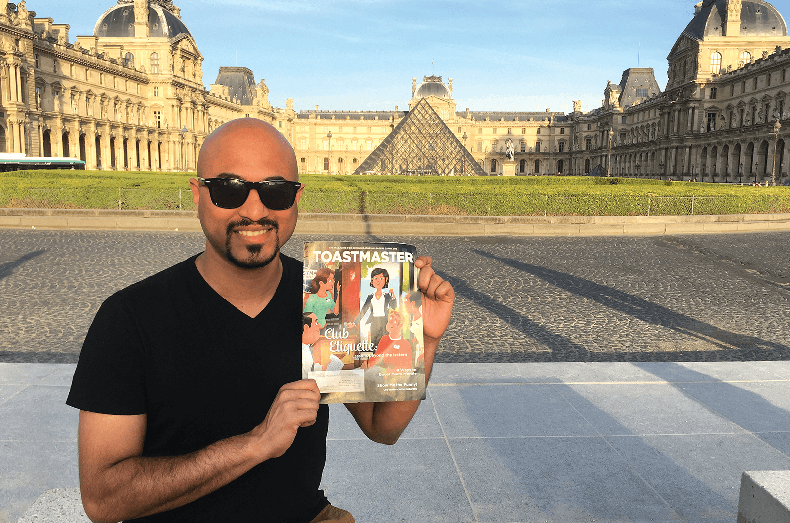 Sarvesh Naik of Houston, Texas, smiles in front of the Louvre Museum’s Glass Pyramid in Paris, France.