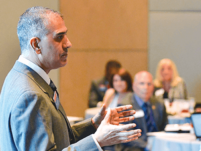 Past International President Mohammed Murad gestures speaking to audience