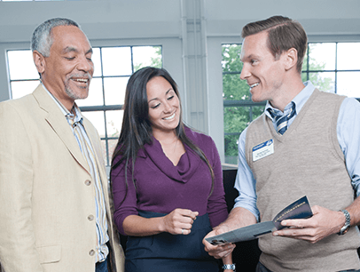 Two men speak with woman in middle