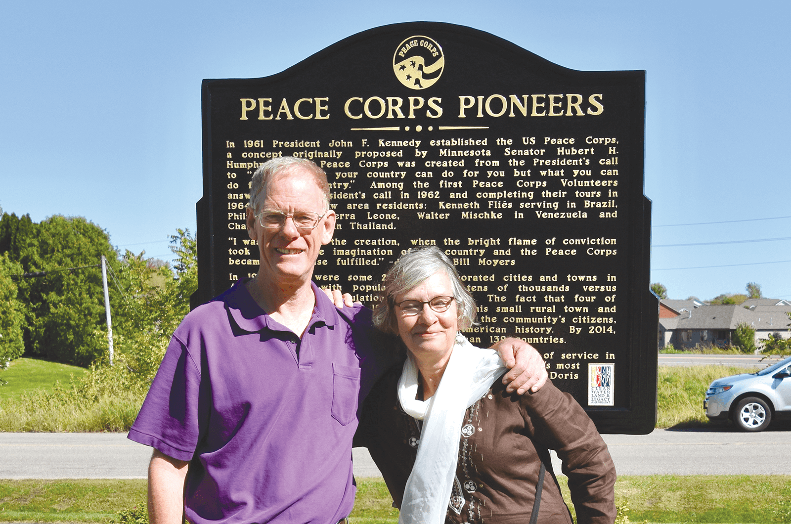 Daniel Grundtner and Ruth Alliband stand in front of a Peace Corp sign in Minnesota.