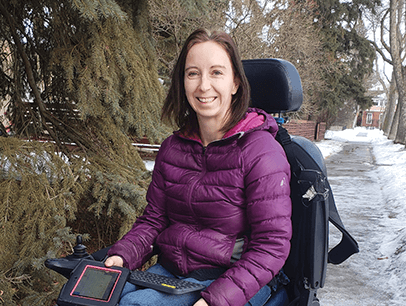 Girl in purple coat poses in wheelchair