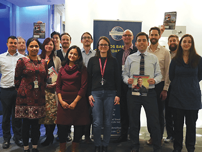 Group of Toastmasters members standing with banner