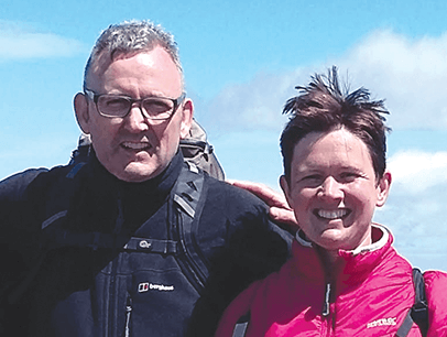 Man and woman wearing coats pose outdoors