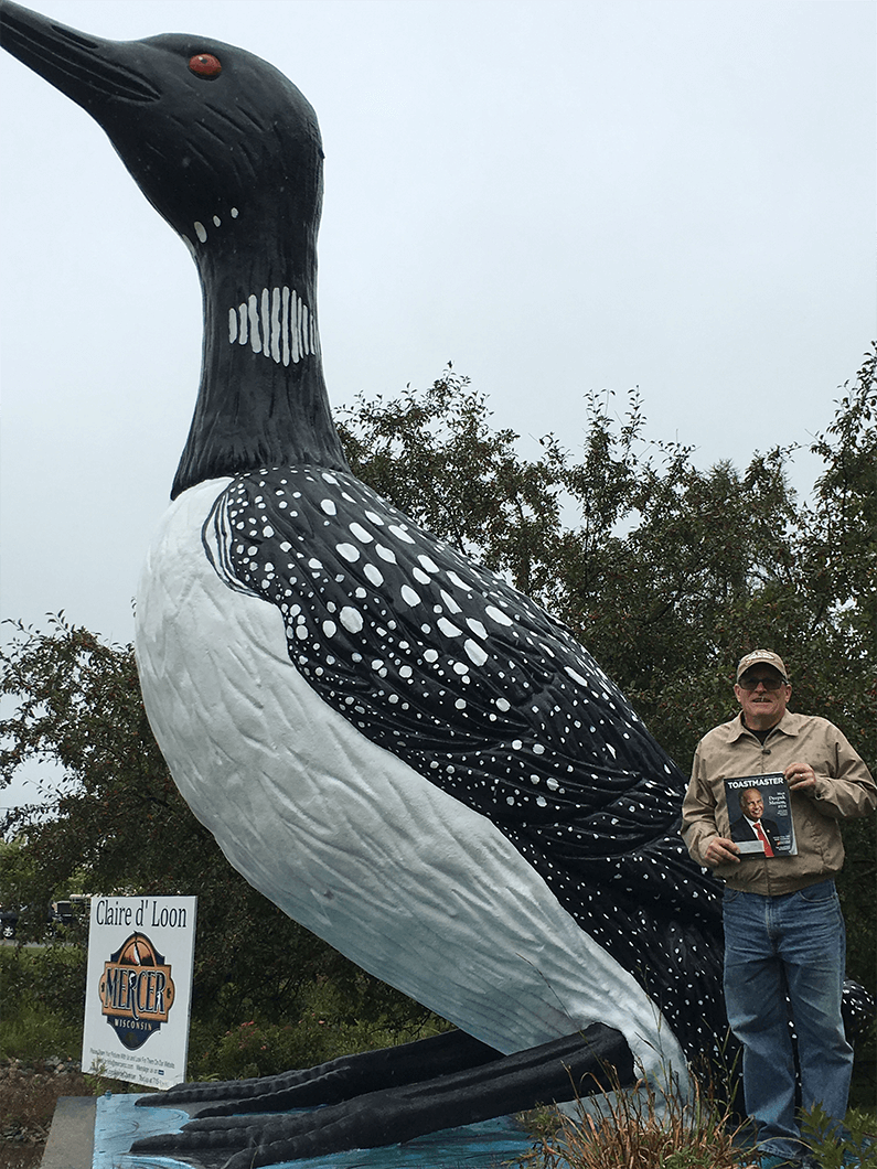 Andrew Safranski of Neenah, Wisconsin, poses with the World’s Largest Talking Loon in Mercer, Wisconsin. The statue stands 16 feet tall in front of the Mercer Chamber of Commerce building, where is has been since 1981.