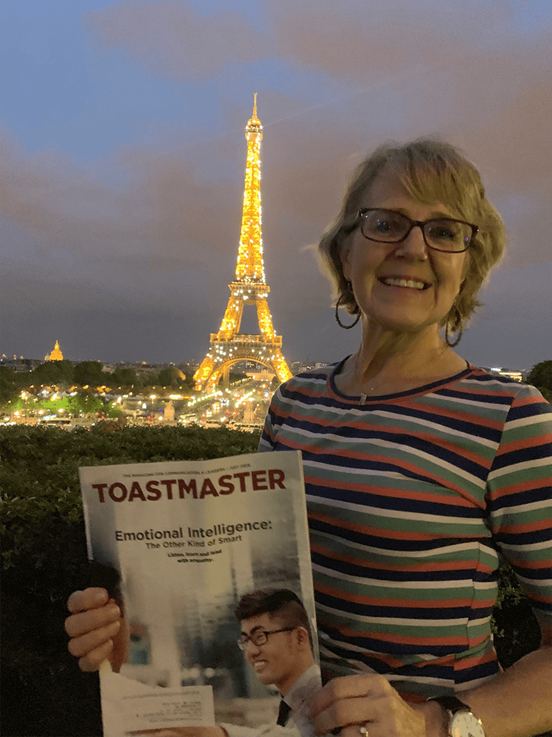 Becky Tripp of Amherst, New Hampshire, poses with her Toastmaster in front of the Eiffel Tower in Paris, France.