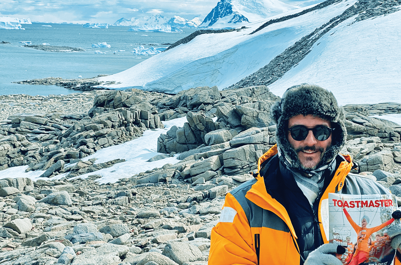 David Fraquelli of Los Angeles, California, U.S., explores Antarctica with his Toastmaster magazine in hand.