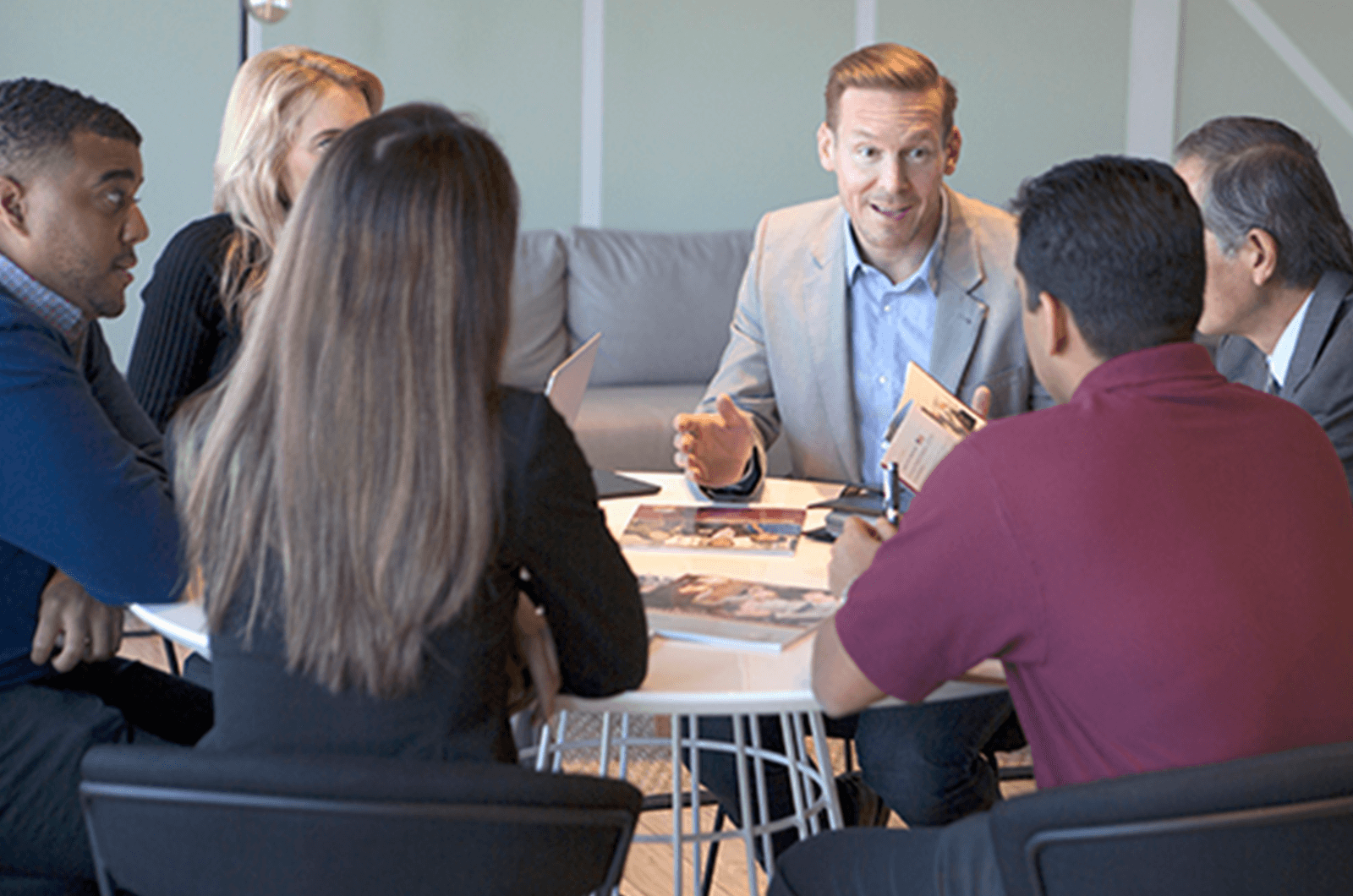 Men and women sitting around a conference table talking
