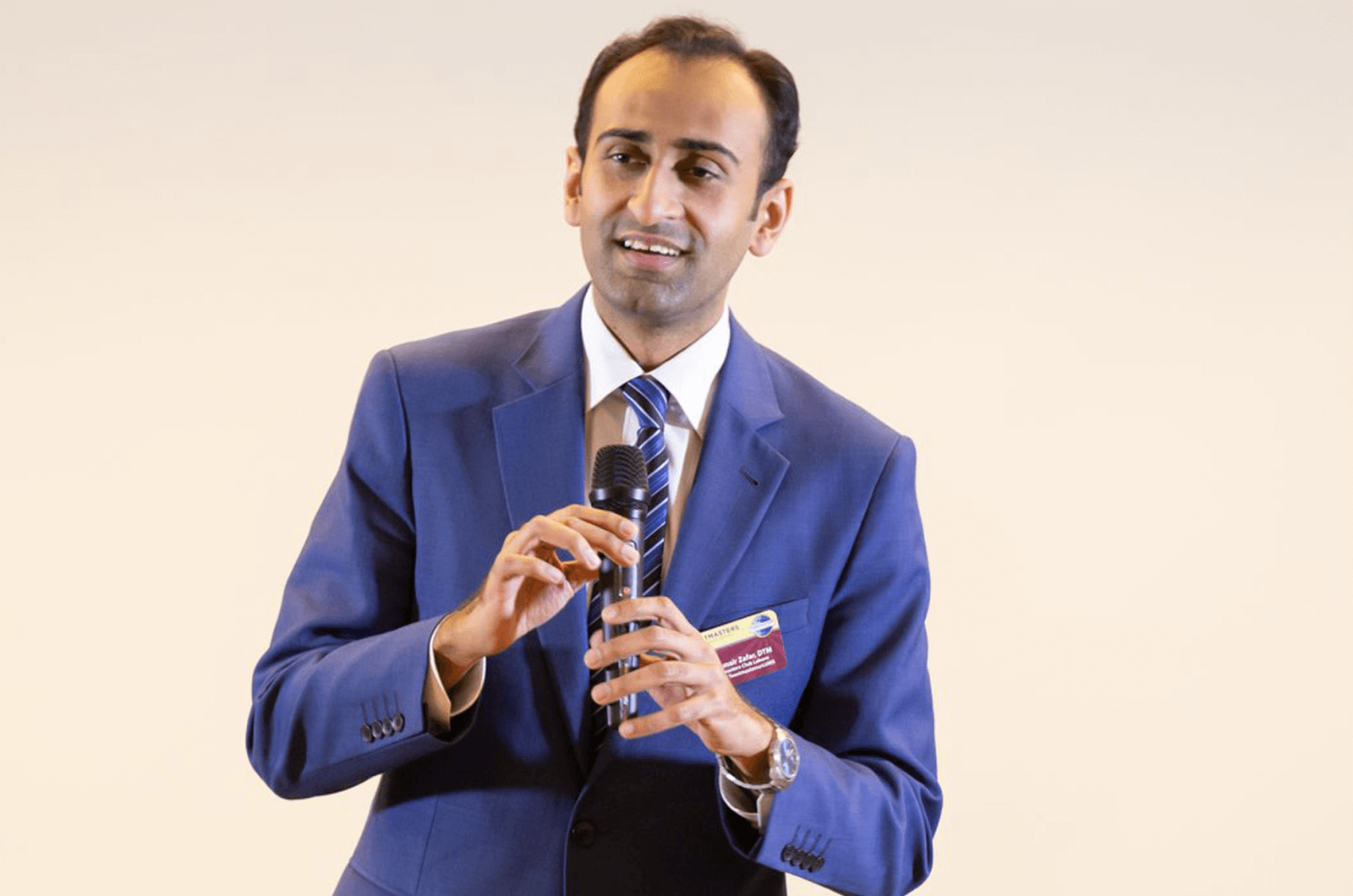 Man wearing blue suit and talking in microphone