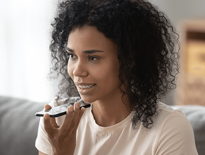 Woman holding up cellphone to her mouth to talk