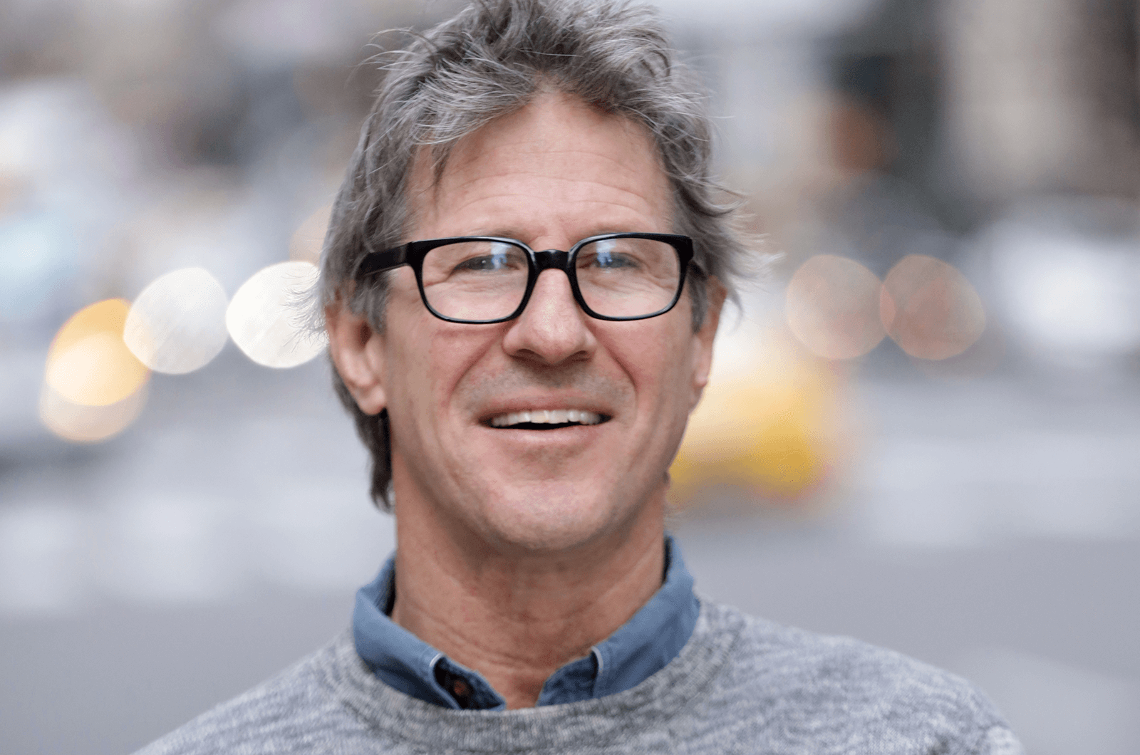 John Bowe posing in gray sweater