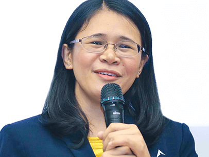 Woman in blue jacket speaking into microphone