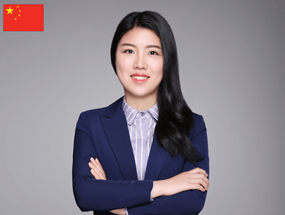 Julia Gu in suit jacket crossing arms and smiling