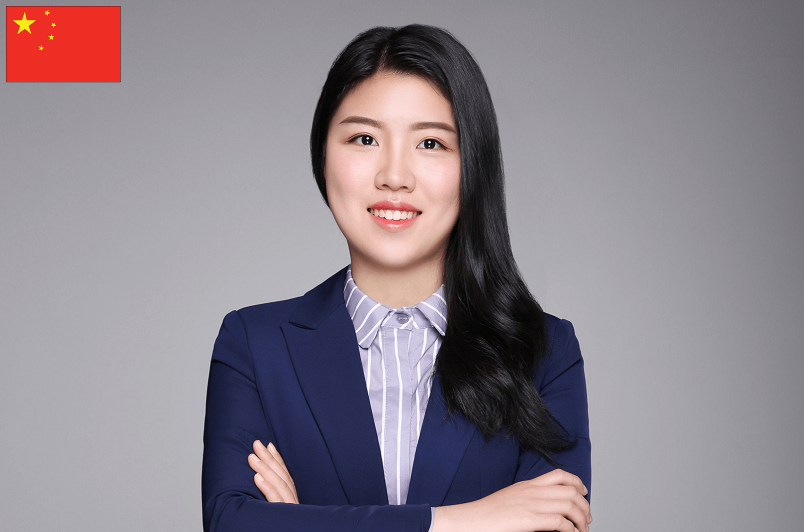 Julia Gu in suit jacket crossing arms and smiling