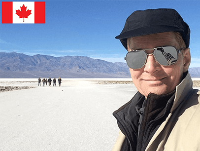 Man posing outdoors wearing hat and sunglasses