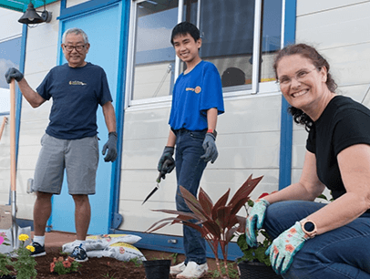 Three people working outside on garden project