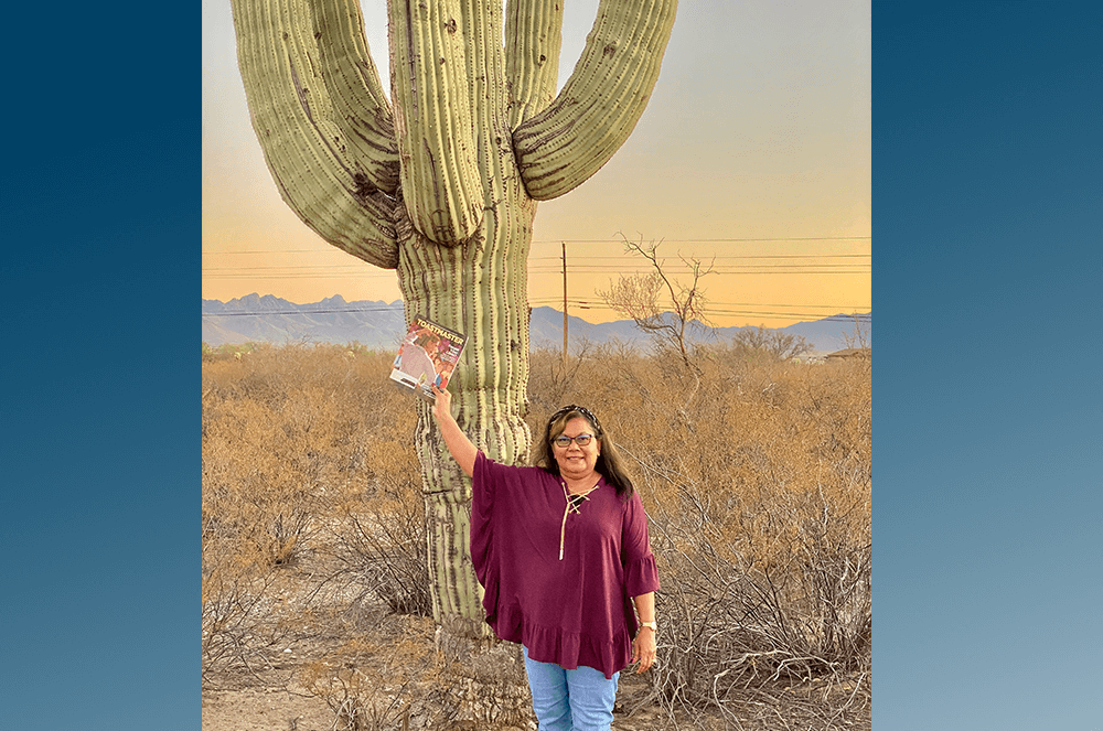 Pim Parpart, DTM, of Melbourne, Florida, shares her Toastmaster magazine with a cactus in Tucson, Arizona.