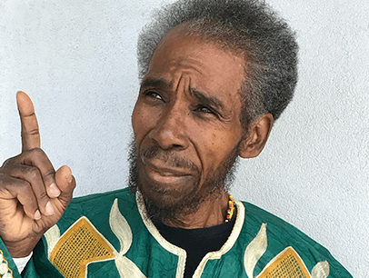 Man in green jacket pointing finger up