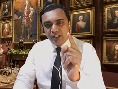 Man speaking to camera holding up finger