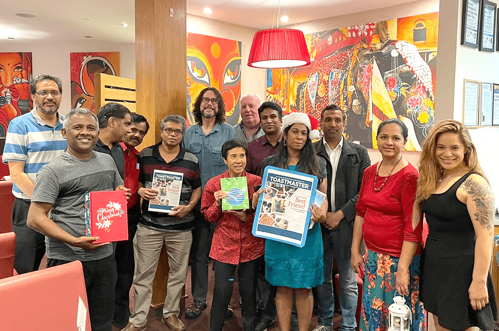 Members of Epping Club of Epping, Victoria, Australia, enjoy a holiday dinner and printouts of the Toastmaster magazine.
